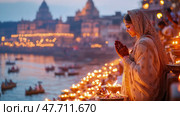 Diwali Night Prayer: A Hindu Woman's Devotion on the Ganges Riverbank, Lit by Countless Lamps and Floating Boats, for Card, Poster. Стоковое AI-изображение, AI-художник Данила Большаков / Фотобанк Лори
