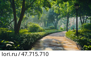 Picturesque scene of green city park with paved path surrounded by lush foliage and trees. Morning sunlight filters through the treetops, creating soft shadows and an atmosphere of calm. Passersby are visible enjoying their walk. The whole space looks well-groomed and natural at the same time - a perfect example of harmonious urban landscaping and public space. The photo is perfect for topics related to ecology, urban environment, outdoor recreation and improvement. Стоковое AI-изображение, AI-художник Анна Кривицкая / Фотобанк Лори