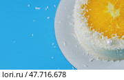 Cake with orange and coconut shavings spinning on a blue background. Стоковое видео, видеограф Mikhail Davidovich / Фотобанк Лори
