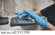The veterinarian is typing on the keyboard in blue gloves. Стоковое видео, видеограф Mikhail Davidovich / Фотобанк Лори