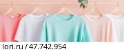 Pastel Apparel: A rack of cozy, muted-tone sweatshirts, perfect for a trendy, minimalist wardrobe concept, ideal for online store or print advertisement. Стоковое AI-изображение, AI-художник Данила Большаков / Фотобанк Лори