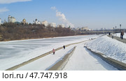 Orel city embankment in winter. Frozen Oka River. People walking along shore. White snow and bright blue sky. Urban landscape. Beautiful Russian city. Редакционное фото, фотограф Ирина / Фотобанк Лори
