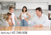 At home in kitchen, outraged mom and dad scold their son and daughter for disobedience. Стоковое фото, фотограф Яков Филимонов / Фотобанк Лори