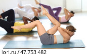 Multinational Pilates participants pulls elbows up to opposite knee, performs exhausting exercises. Стоковое видео, видеограф Яков Филимонов / Фотобанк Лори