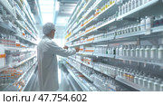 A pharmacist is arranging prescription bottles on neatly organized shelves in a bright, spacious pharmacy. Стоковое AI-изображение, AI-художник Данила Большаков / Фотобанк Лори