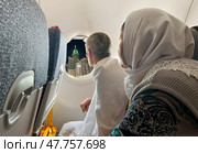 An elderly woman and man in ihram land on a plane in Mecca. The famous Royal Clock Tower in Mecca. Редакционное фото, фотограф Луиза Налимова / Фотобанк Лори
