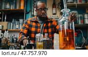 A scientist carefully observes vibrant liquids in glass beakers and flasks while conducting an experiment in a busy laboratory. Стоковое AI-изображение, AI-художник Данила Большаков / Фотобанк Лори
