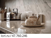 On the marble countertop of the kitchen there is a pewter enameled cream-colored teapot with a floral pattern on a porcelain saucer, created with Generative AI. Стоковое AI-изображение, AI-художник Данила Большаков / Фотобанк Лори