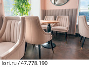 Empty beige upholstered chairs in a coffee shop in the morning. Стоковое фото, фотограф Артем Курутин / Фотобанк Лори