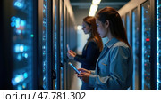Two Professionals Are Engaged in Their Tasks Within a Modern Server Room Filled With Computer Servers. Стоковое AI-изображение, AI-художник Sergey Grishin / Фотобанк Лори