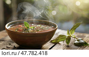 A bowl of soup sitting on a wooden table, ready to be enjoyed. Стоковое AI-изображение, AI-художник Данила Большаков / Фотобанк Лори
