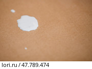 Close up of a white paint splatter spilled on a brown kraft paper surface. Стоковое фото, фотограф Мария Мороз / Фотобанк Лори