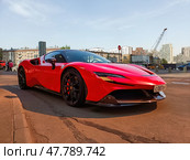 Red Ferrari SF90 Stradale parked on the street in Moscow. Supercar in urban landscape. Редакционное фото, фотограф Константин Григорьев / Фотобанк Лори