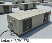 Large Beige Air Conditioning Units Sit Atop a Commercial Building Under a Bright Sky. Стоковое AI-изображение, AI-художник Sergey Grishin / Фотобанк Лори