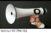 A hand firmly grips a white and black megaphone, ready for amplification and communication. Стоковое AI-изображение, AI-художник Данила Большаков / Фотобанк Лори