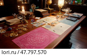 Intricate tabletop display of mystical artifacts and ancient manuscripts in a dimly lit room. Стоковое AI-изображение, AI-художник Сергей Толмачёв / Фотобанк Лори