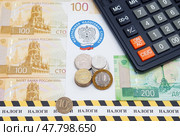 Письмо с эмблемой Федеральной налоговой службы, оградительная лента с надписью "налоги", калькулятор и российские деньги. Редакционное фото, фотограф Цибаев Алексей / Фотобанк Лори