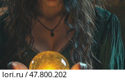 Mystical woman gazing into glowing crystal ball in enchanted forest setting. Стоковое AI-видео, аниматор Sabyna75 / Фотобанк Лори