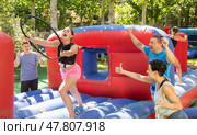 Cheerful girl having funny competition in collect of hoops on inflatable trampoline. Стоковое фото, фотограф Яков Филимонов / Фотобанк Лори