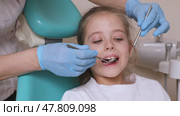 Close up dentist, doctor examines the oral cavity of a little girl, uses a mouth mirror, baby teeth close-up, the concept of pediatric dentistry, dental treatment. Стоковое видео, видеограф Ирина Михайличенко / Фотобанк Лори