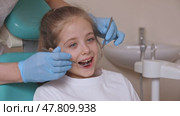 Close up dentist, doctor examines the oral cavity of a little girl, uses a mouth mirror, baby teeth close-up. Concept of pediatric dentistry, dental treatment. Slow motion footage. Стоковое видео, видеограф Ирина Михайличенко / Фотобанк Лори