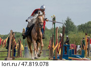 SAINT PETERSBURG, RUSSIA - SEPTEMBER 14, 2024: A warrior in medieval Russian armor chops an apple while galloping. Demonstration performances of the historical reconstruction club at the city festival "Spirit of Time" Редакционное фото, фотограф Виктор Карасев / Фотобанк Лори