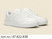 Stylish sneakers. Sports and casual clothing style. Summer or spring fashion. White leather lace-up running city shoe with low on a beige. Rubber outsole. Sporty look. Street hiking. Trendy Boots Pair. Стоковое AI-изображение, AI-художник Марина Демидюк / Фотобанк Лори