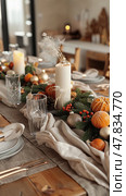 Elegant autumn tablescape with pumpkins and candles for a cozy seasonal dinner. Стоковое AI-изображение, AI-художник Zakharova Natasha / Фотобанк Лори