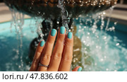 Aqua nails shimmer against a fountain's sparkling water in the sun. Ногти цвета аква мерцают на фоне искрящейся на солнце воды фонтана. Стоковое AI-изображение, AI-художник Katsiaryna Repich / Фотобанк Лори