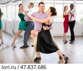 Woman dances incendiary tango with man partner during choreography lesson. Стоковое фото, фотограф Яков Филимонов / Фотобанк Лори