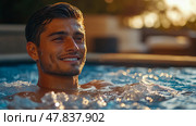 A young man smiles contentedly while floating in a pool, surrounded by lush greenery and warm sunset light, creating a peaceful atmosphere. Стоковое AI-изображение, AI-художник Данила Большаков / Фотобанк Лори