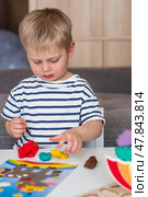 A little boy is playing with plasticine. Fine motor skills-developing games for children. The kid makes a horse. Useful games for child development. Стоковое фото, фотограф Photojuli / Фотобанк Лори