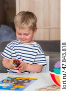 A little boy is playing with plasticine. Fine motor skills-developing games for children. The kid makes a horse. Useful games for child development. Стоковое фото, фотограф Photojuli / Фотобанк Лори