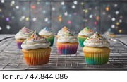 Sugar sprinkles falling on stack of colorful cupcakes. Стоковое AI-видео, аниматор Ирина Старикова / Фотобанк Лори