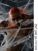Woman with red hair ensnared in a net amid a web-like trap. Стоковое фото, фотограф Гурьянов Андрей / Фотобанк Лори