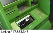 Russia, Sosnovy Bor, April 18, 2025 - Customer withdrawing cash and taking receipt at green atm. Редакционное видео, видеограф Андрей Знаменский / Фотобанк Лори