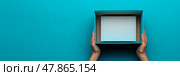 Two hands grasp an open, empty box on a bright blue background, suggesting preparation for a gift or organization task in a creative space. Стоковое AI-изображение, AI-художник Данила Большаков / Фотобанк Лори