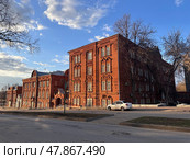 A large red brick building with a white car parked in front of it. Sarov city, Nizhny Novgorod region. Стоковое фото, фотограф Надежда Кап / Фотобанк Лори
