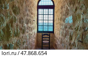 A beautifully designed narrow stone hallway featuring an ornate window and an inviting chair. Стоковое видео, видеограф Vladimir Vintonjak / Фотобанк Лори