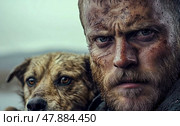 A weathered man with a fierce expression and a dirty face gazes intently, while a scruffy dog sits close beside him in a bleak outdoors. Стоковое AI-изображение, AI-художник Данила Большаков / Фотобанк Лори