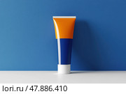 Orange white tube with suntan lotion, cosmetic face cream or hand cream, shower gel, against the blue color wall. Studio background. Blank plastic package mockup. Skincare product template. Стоковое AI-изображение, AI-художник Марина Демидюк / Фотобанк Лори