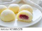 Delicious Japanese Yellow moti desserts. Close up. Asian rice daifuku dessert sweet mochi. Cut in half with red jam filling. Traditional dessert mochi. Colorful cake. Fukashi manju. Culinary delight. Стоковое AI-изображение, AI-художник Марина Демидюк / Фотобанк Лори