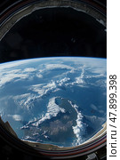 A view of Earth from a space station window, showing the planets curvature, oceans, continents, and clouds. Стоковое AI-изображение, AI-художник Данила Большаков / Фотобанк Лори