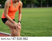 Женщина-бегунья наклоняется, касаясь колена, испытывая боль и дискомфорт  из-за спортивной травмы. Здравоохранение или медицинская концепция, связанная с проблемами со здоровьем и физической формой. Стоковое AI-изображение, AI-художник Анжелика Самсонова / Фотобанк Лори