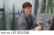 Young man workshop employee switches toggle switch on control panel. Стоковое видео, видеограф Яков Филимонов / Фотобанк Лори