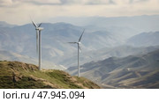 The wind farm nestled in a mountainous region, with turbines towering over scenic valleys, clean energy in rugged terrain. Стоковое AI-видео, аниматор Михаил Строгалев / Фотобанк Лори