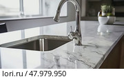 Close-up of a clean marble countertop in kitchens with gleaming stainless steel tap. Стоковое AI-видео, аниматор Михаил Строгалев / Фотобанк Лори