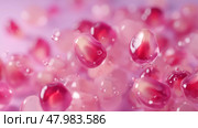 Bright red pomegranate seeds glisten with drops of water on a smooth surface during a soft, illuminated setting. Стоковое AI-изображение, AI-художник Сергей Толмачёв / Фотобанк Лори