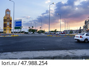 Bright sunset over a busy roundabout with a clock tower and palm trees in the city. Стоковое фото, фотограф Сергей Толмачёв / Фотобанк Лори