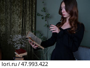 An Enchanting Sorceress is deeply engrossed in reading a Spellbook surrounded by swirling, Mystical Smoke. Стоковое фото, фотограф Anastasy Yarmolovich / Фотобанк Лори